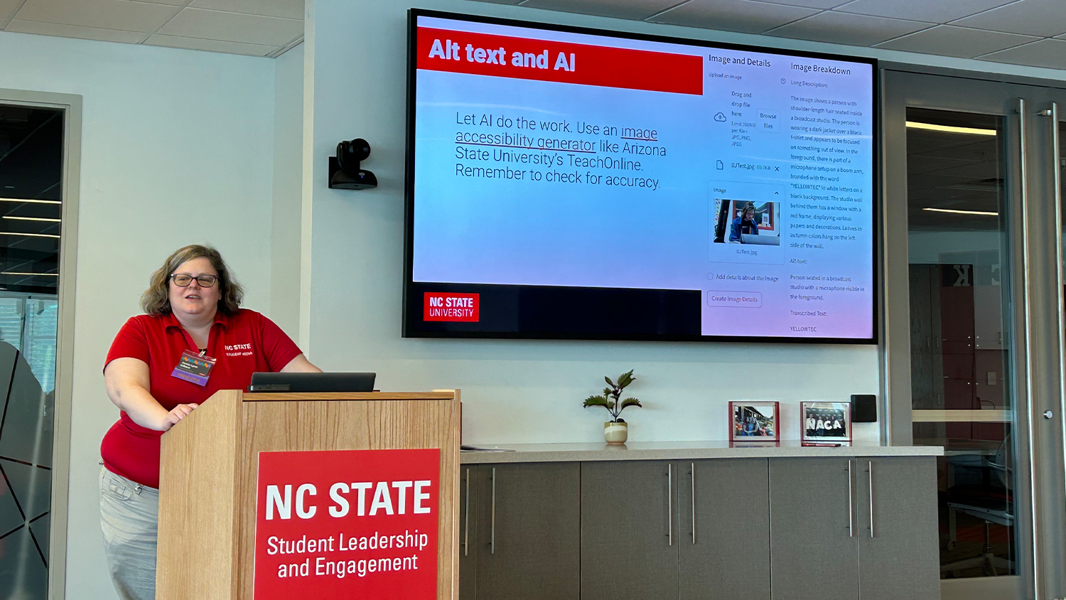 Person at a podium presenting a slide on alt text and AI.